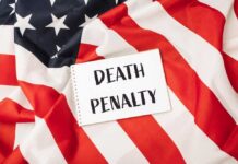 A sign reading 'DEATH PENALTY' placed on an American flag