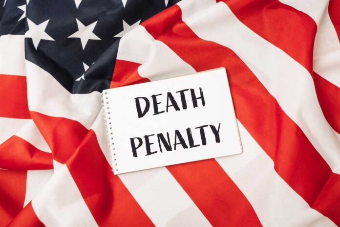 A sign reading 'DEATH PENALTY' placed on an American flag