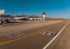 Route 66 Obsession Turns Into USPS Tribute A deserted stretch of Route 66 featuring a cafe and vintage signs