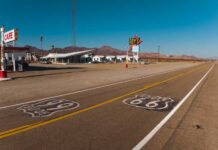 A deserted stretch of Route 66 featuring a cafe and vintage signs