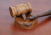 A wooden gavel resting on a circular base