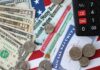 Stock Market Soars As Americans Struggle With THIS! Various denominations of U.S. currency and financial documents on a flag background