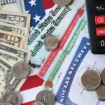 Stock Market Soars As Americans Struggle With THIS! Various denominations of U.S. currency and financial documents on a flag background