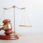 Massive Sentence Awaits Shooter in University Tragedy A wooden gavel in front of a balance scale symbolizing justice