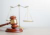 Last-Minute Supreme Court Order Upends Democrats A wooden gavel in front of a balance scale symbolizing justice