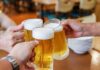 177-Year-Old Beer’s Shocking End! Three hands clinking frothy beer mugs