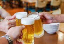 177-Year-Old Beer’s Shocking End! Three hands clinking frothy beer mugs