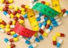 Colorful capsules scattered with a measuring tape