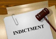 Communist Leader Faces U.S. Murder Indictment Gavel on a white paper with the word indictment on it.