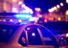 Curfew Chaos: Teens To Feel Police Pressure Police car with flashing blue lights at night.