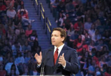 DeSantis Declares Victory Person speaking at podium in front of large audience.