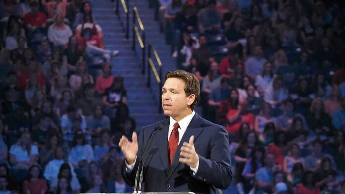 Person speaking at podium in front of large audience.