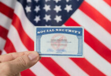 UPDATE: Social Security Cuts Coming Sooner?! Hand holding social security card, American flag background.