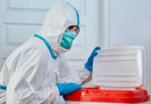 Ebola Panic Grips Another Country?! Healthcare worker in protective gear disposing of waste
