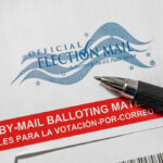 Banned Database Threatened Millions Of Votes? Vote-by-mail envelope with pen on top.