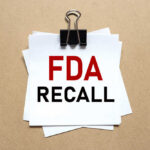 Recall Alert: FDA Slaps Highest Risk A notice labeled 'FDA RECALL' clipped to white papers on a brown background