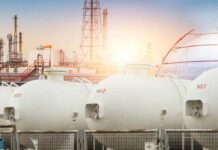 Oil Price Panic Triggered? Gas storage tanks in an industrial facility during sunrise