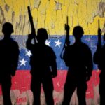 Silhouettes of soldiers in front of the Venezuelan flag