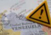 A close-up of a map of Venezuela with a yellow warning sign