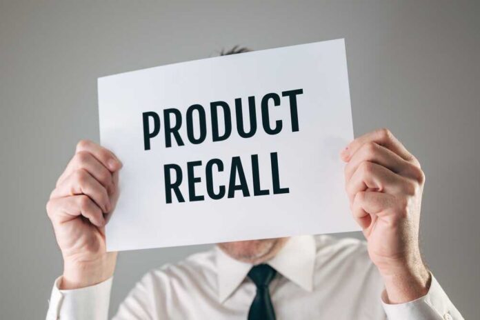 Businessman,Holding,A,White,Paper,Sign,With,Product,Recall,Text Person holding a sign reading product recall