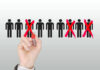 9,000 Jobs Vanish — Details Hand crossing out stick figures with a red marker.