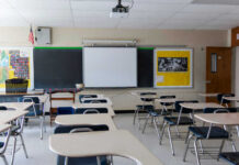 New School Hall Monitor: Drones? Empty classroom with desks, projector, and chalkboard.