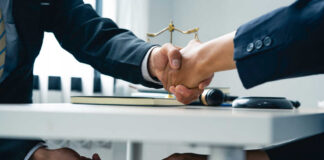 Businessmen handshake while cash is passed under the table