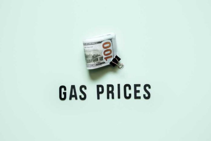 Gas,Prices,,Energy,Crisis,Concept.,Gasoline,Prices,Rising.,Stack,Of A bundle of cash next to the words 'GAS PRICES' on a light green background