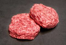 Beef Drops Big — Politics Erupt Two raw ground meat patties on a dark surface