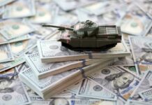 $37.5B? Pentagon’s Iran Math Explodes A toy tank placed on stacks of hundred-dollar bills