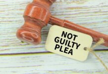 Convicted Killer’s Shocking Reversal A wooden gavel next to a tag that reads 'NOT GUILTY PLEA'