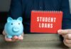 A blue piggy bank and a red notebook displaying 'STUDENT LOANS'