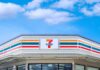 Mass 7‑Eleven Purge Begins convenience store exterior with colorful striped signage under blue sky