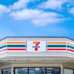 convenience store exterior with colorful striped signage under blue sky