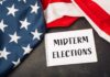 Trump Turns Midterms Into Dallas Showdown American flag and a notebook with 'MIDTERM ELECTIONS' written on it