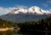 Snow-covered mountain peak partially obscured by clouds
