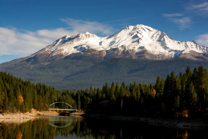 Snow-covered mountain peak partially obscured by clouds