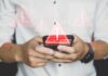 Algorithmic Bouncer Locks Out July 4 Guests Hands holding a smartphone with warning icons overlay