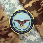 Patriot Shortage Panic? Department of War insignia on camouflage fabric