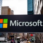Microsoft Slashes Thousands, Blames… Not AI? Microsoft logo displayed on a textured wall