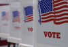 Election Chaos Teed Up By SCOTUS Twist Voting booths with American flags and VOTE signs.