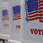 Election Chaos Teed Up By SCOTUS Twist Voting booths with American flags and VOTE signs.