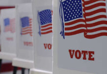 Election Chaos Teed Up By SCOTUS Twist Voting booths with American flags and VOTE signs.