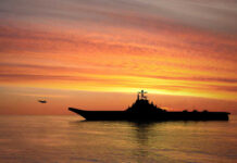 Drought Unmasks WWII Time Bombs Silhouette of an aircraft carrier at sunset.