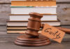 Guilty Words Rock Midtown Killing Case A wooden gavel with a tag reading 'Guilty' next to stacked books