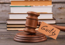 Guilty Words Rock Midtown Killing Case A wooden gavel with a tag reading 'Guilty' next to stacked books