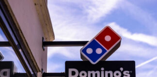 Dominos Pizza store sign with blue sky background