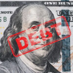 Record Debt Looms — What’s Breaking? Hundred dollar bill with red debt stamp