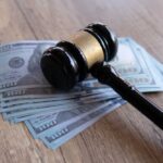Judge’s gavel resting on a stack of US hundred-dollar bills