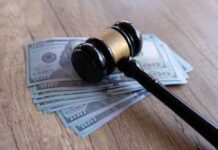 High Court Walks; $5M Bomb Ticks Judge’s gavel resting on a stack of US hundred-dollar bills